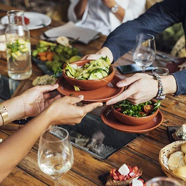 people sharing vegan dishes in restaurant