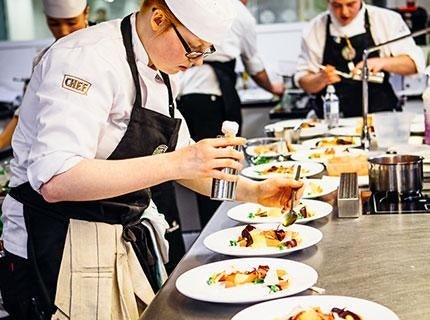 Student plating up in a professional kitchen as part of Nestlé Professional's sustainable futures program Toque d'Or