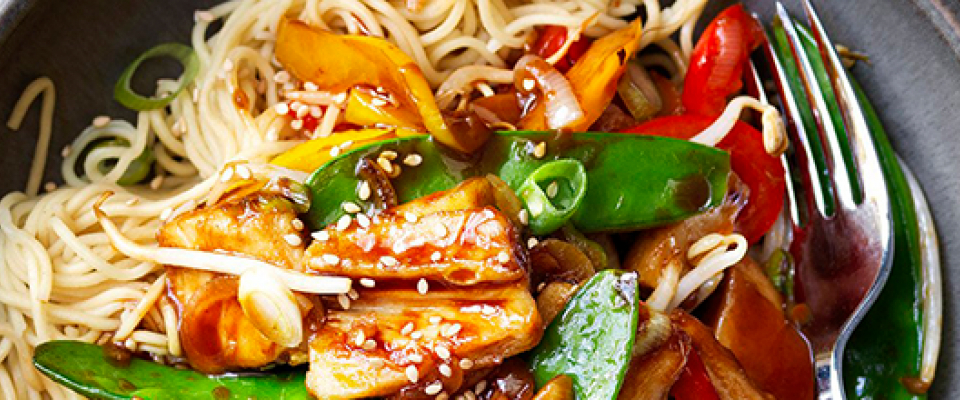 A bowl of vegetables and rice with a fork