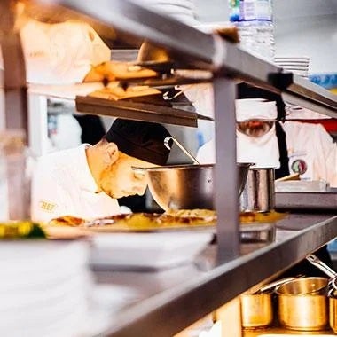 Student chef in a professional kitchen preparing dishes for Nestlé Professional's Toque d'Or competition
