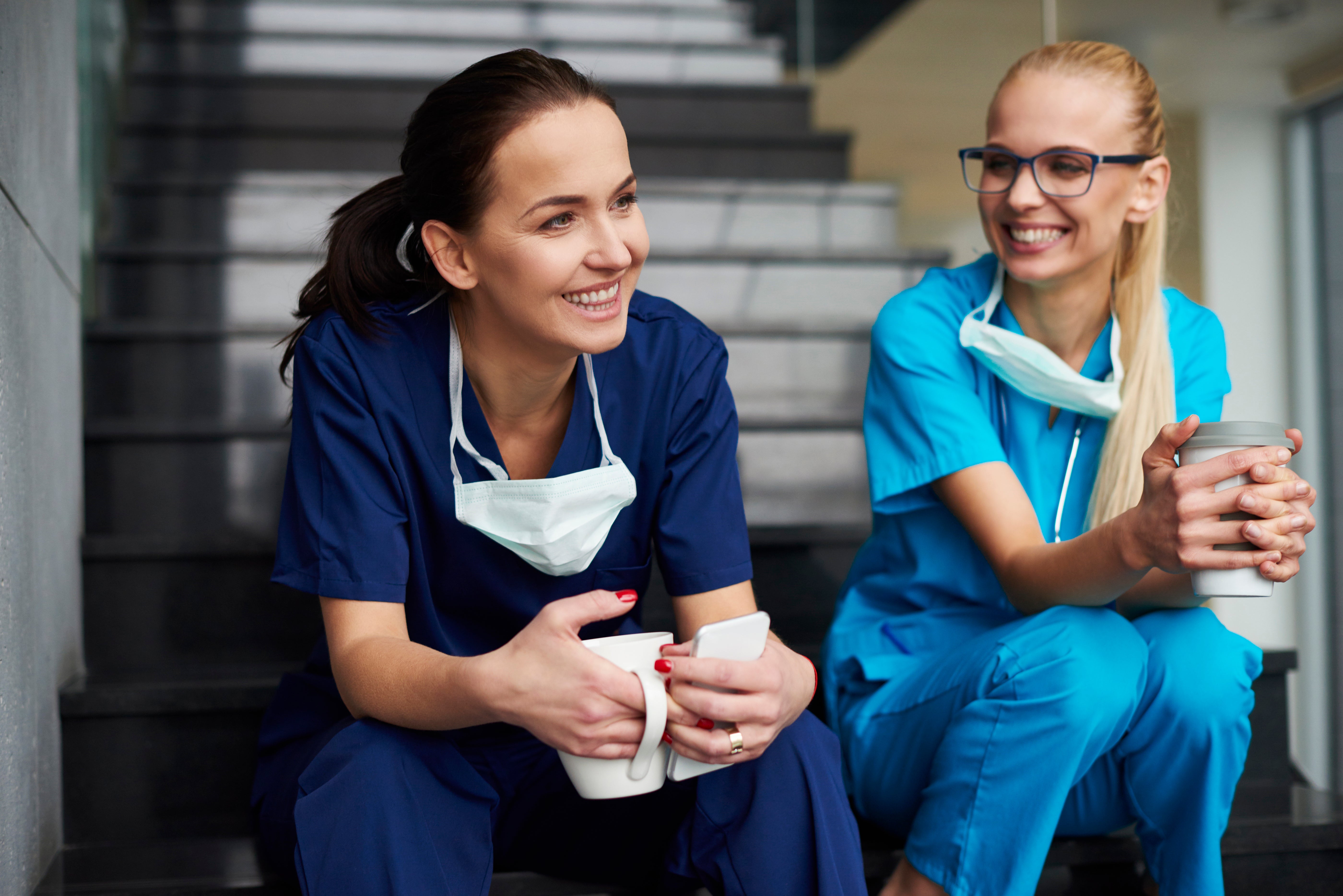 nurses drinking coffee on stairs