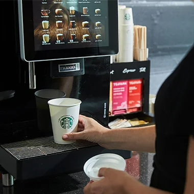 Person selecting a hot beverage from coffee machine