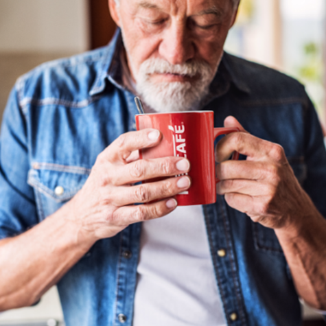 Male about to enjoy a coffee drink from red mug