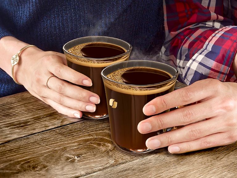 People with hands on two coffee mugs