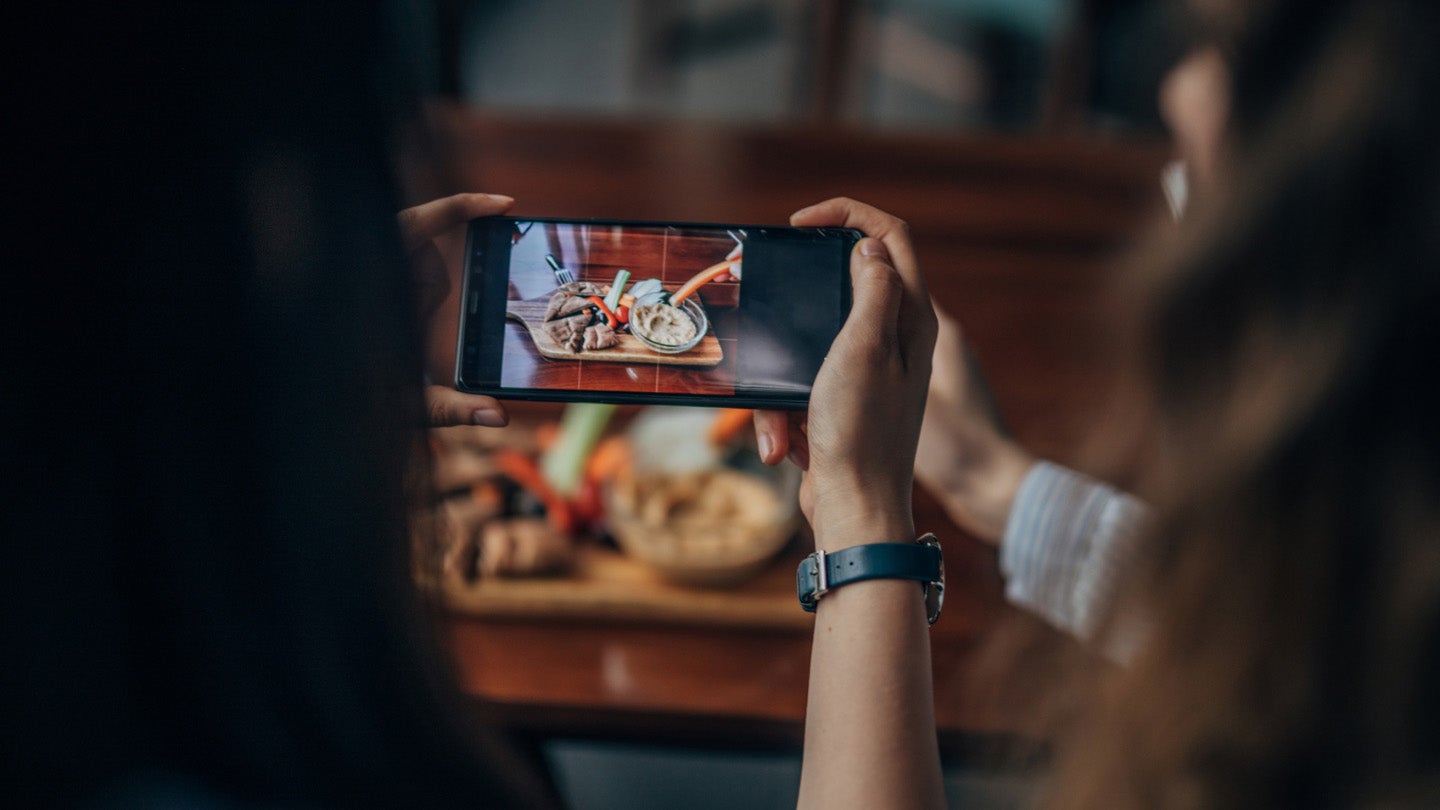 A person taking a picture of food