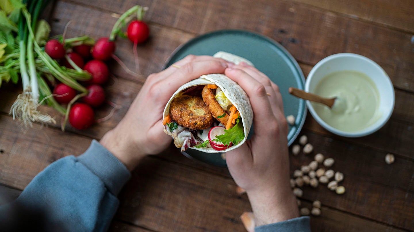 Person holding a vegan wrap