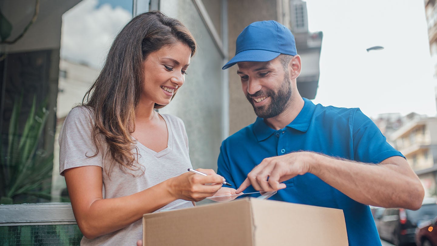 A woman signing for a parcel
