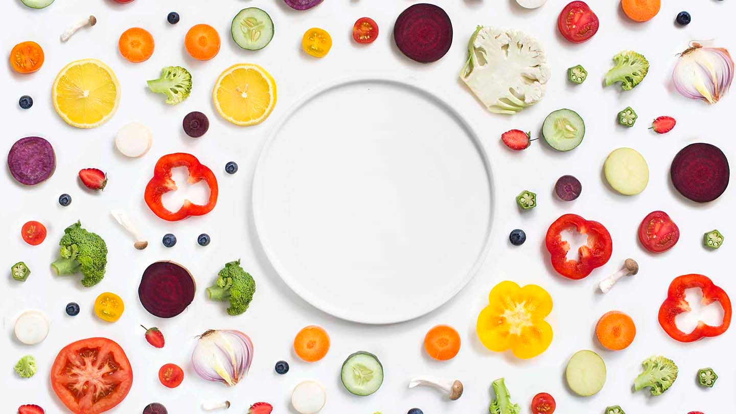 An empty plate surrounded by vegetables