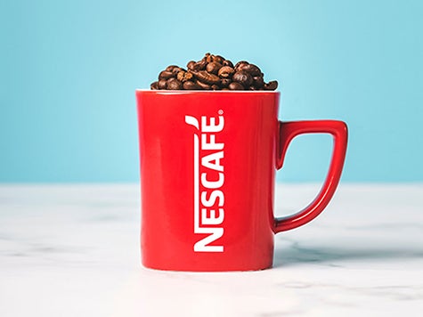 Red Nescafé mug filled with coffee beans