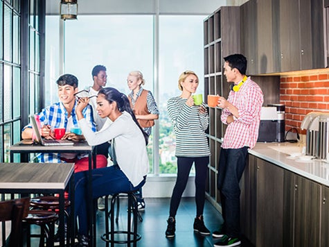 Coworkers gathered in the staff kitchen drinking coffee