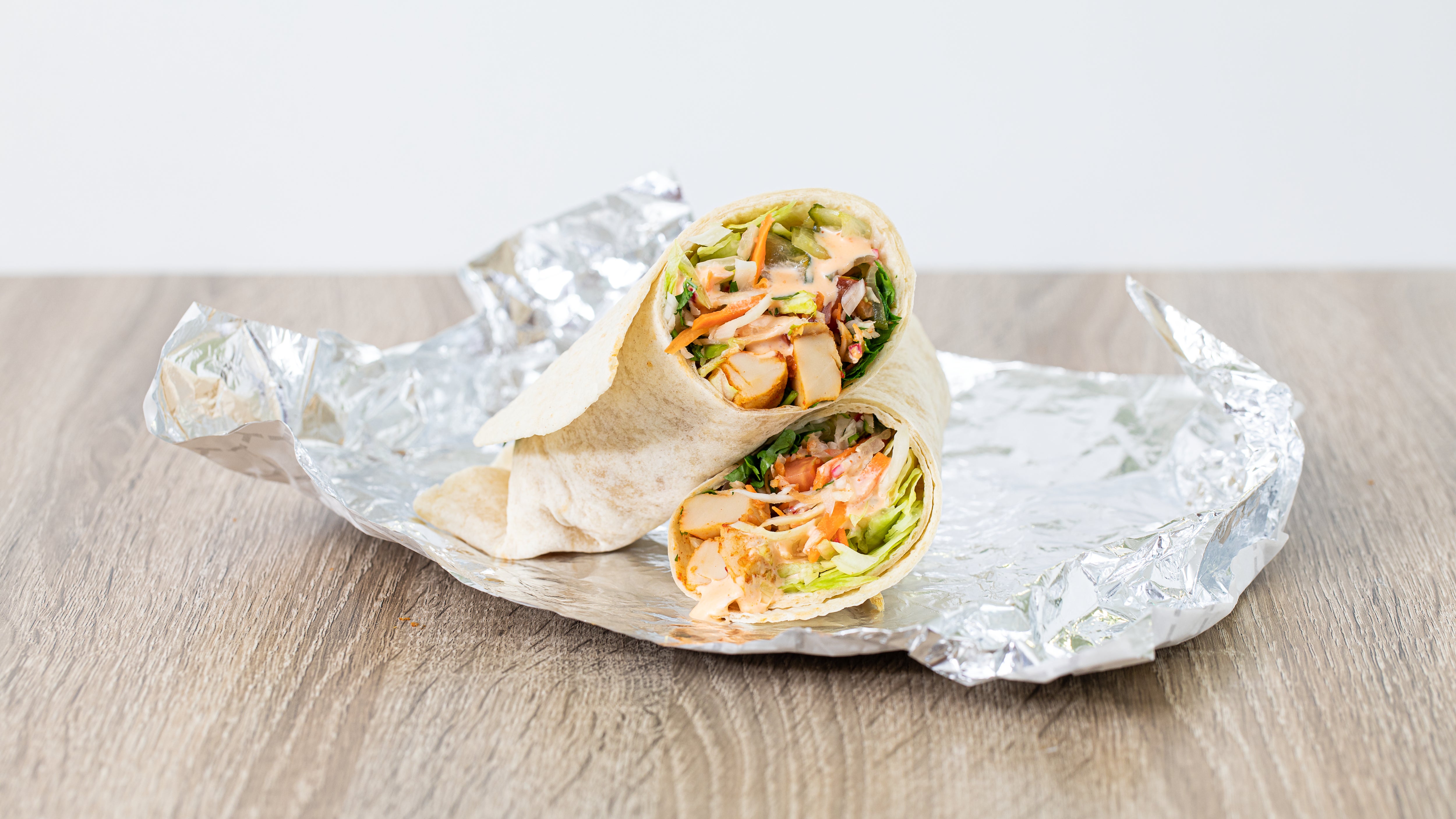 bang bang veggie wrap placed on foil on a table