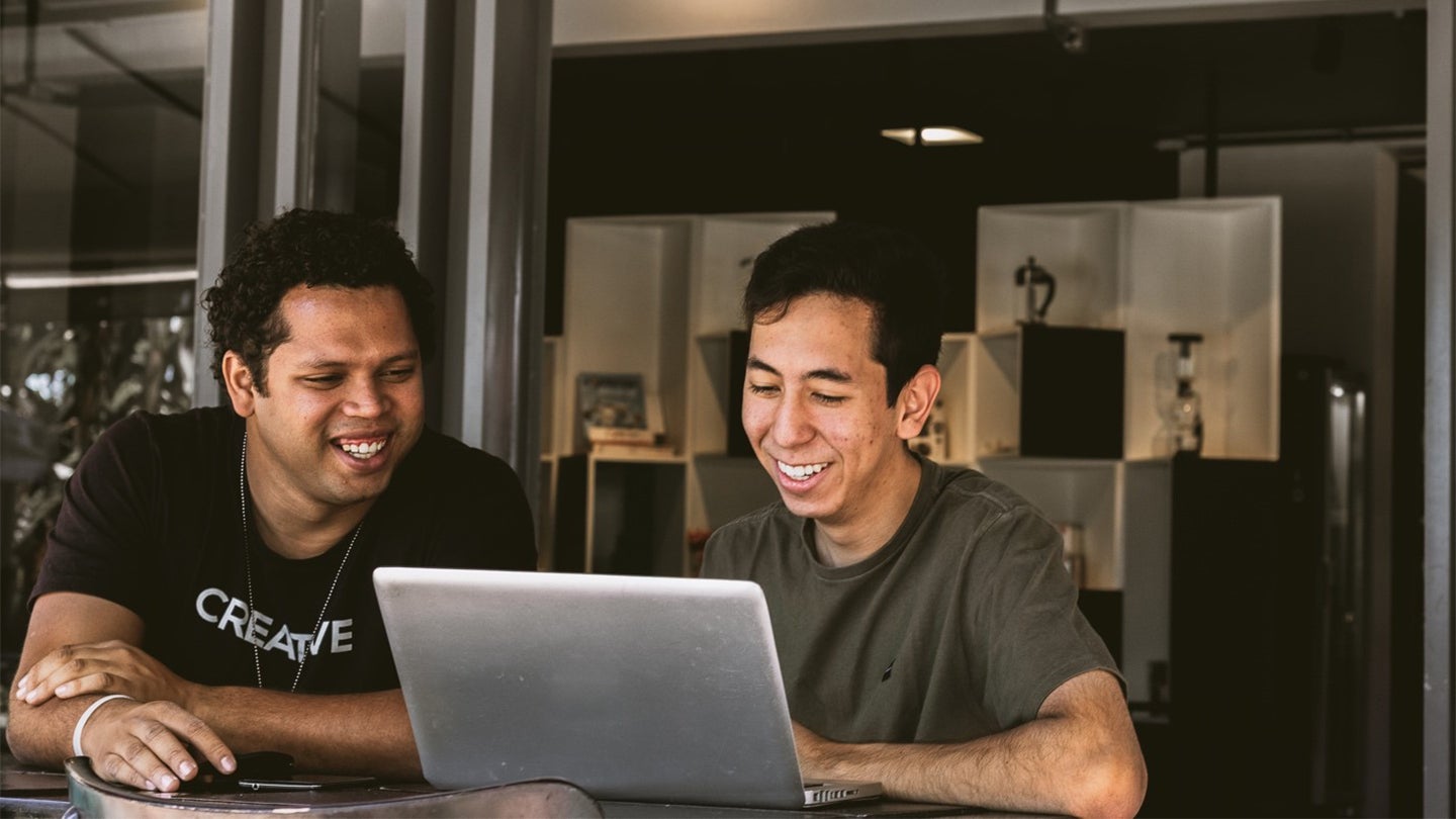 two colleagues looking at a laptop