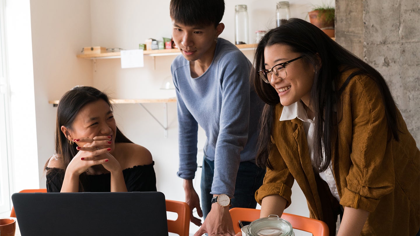 manager coaching two employees sat around a table
