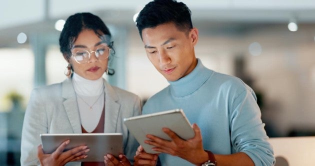 two colleagues working on their tablets together