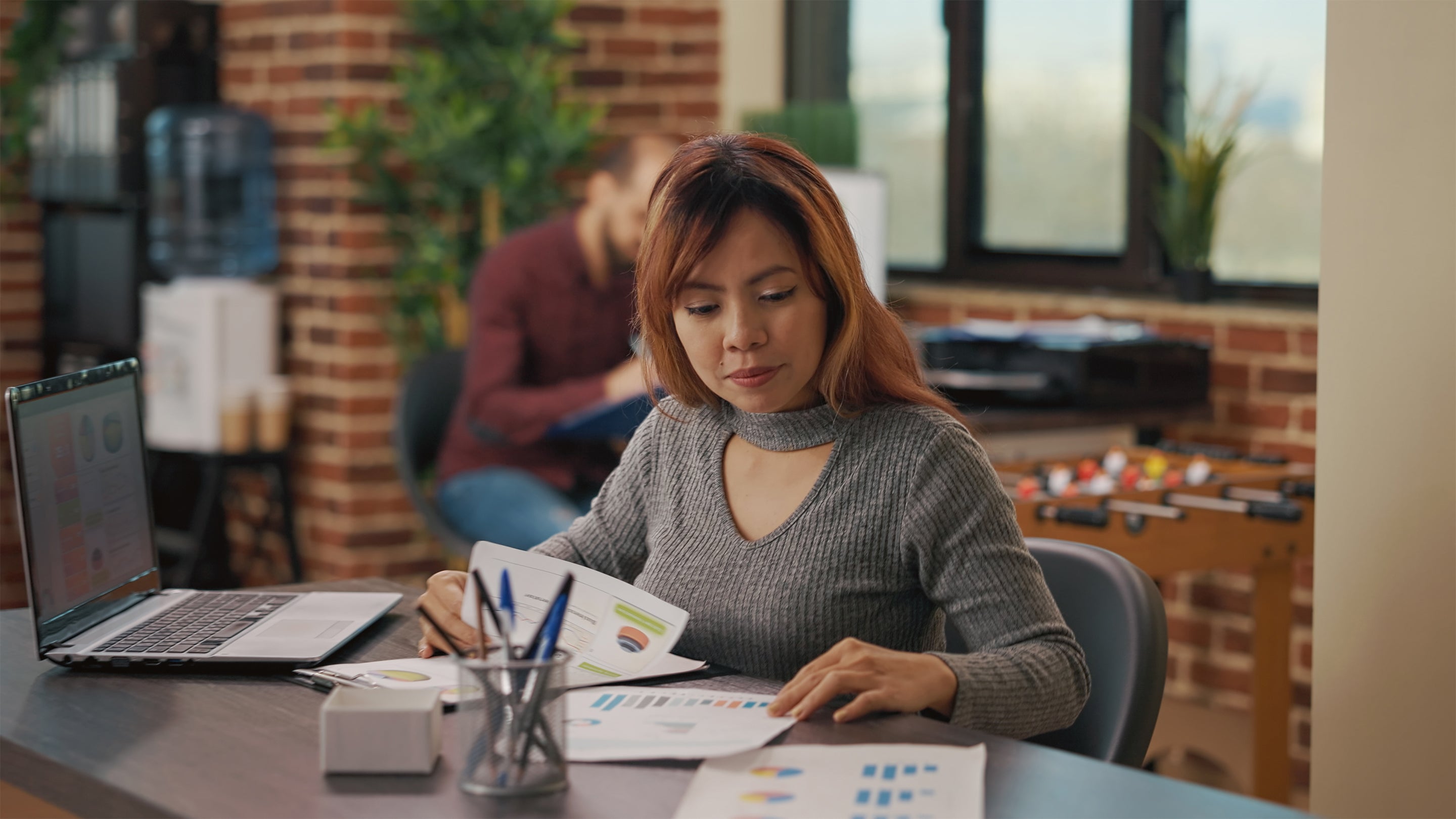woman looking at graphs at her desk