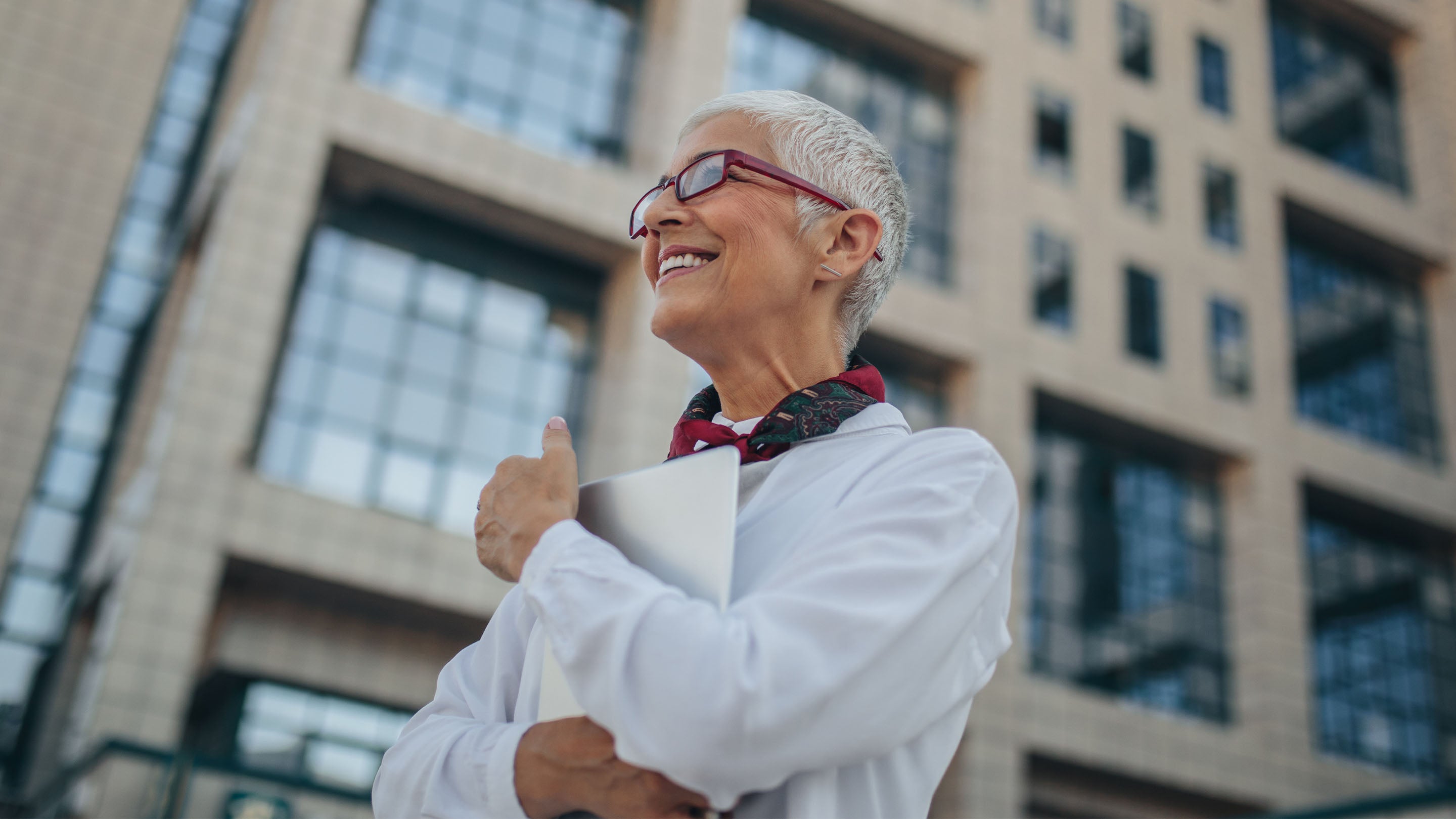 woman smiling outside an office building
