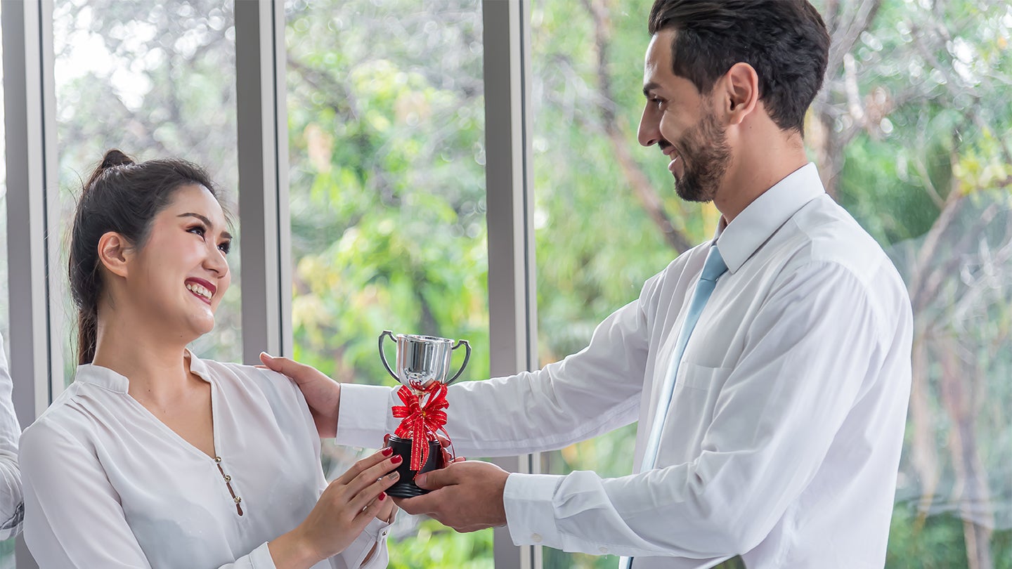 colleagues handing each other trophies