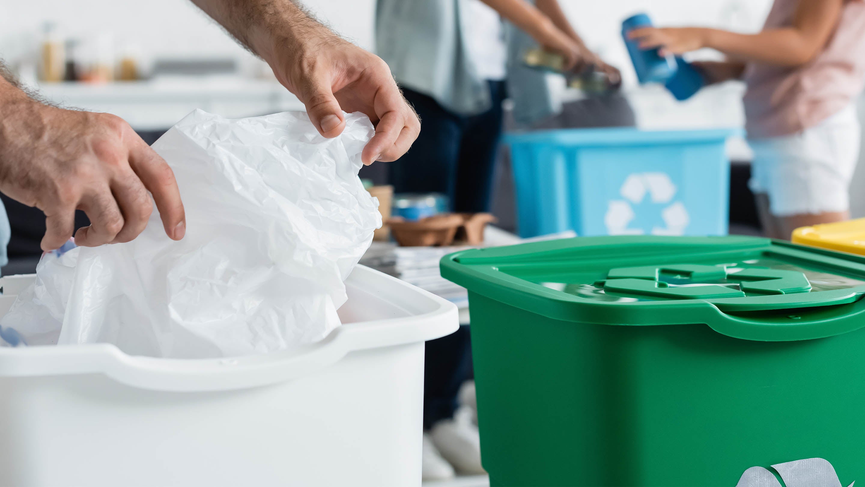 people sorting waste into different recycling bins, promoting environmental sustainability