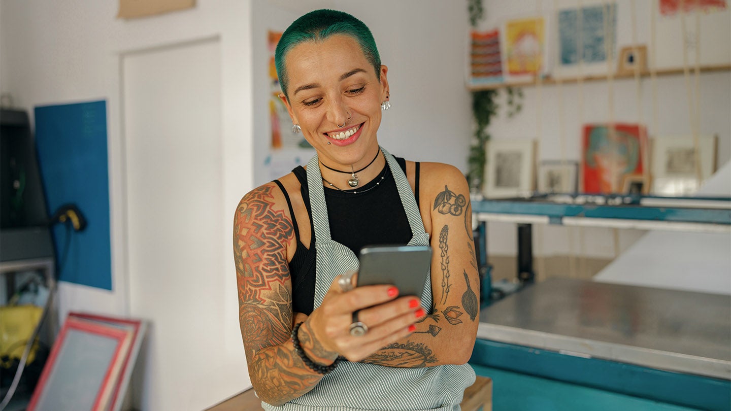 artist in her studio checking phone