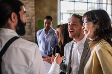 people talking and smiling at a networking event