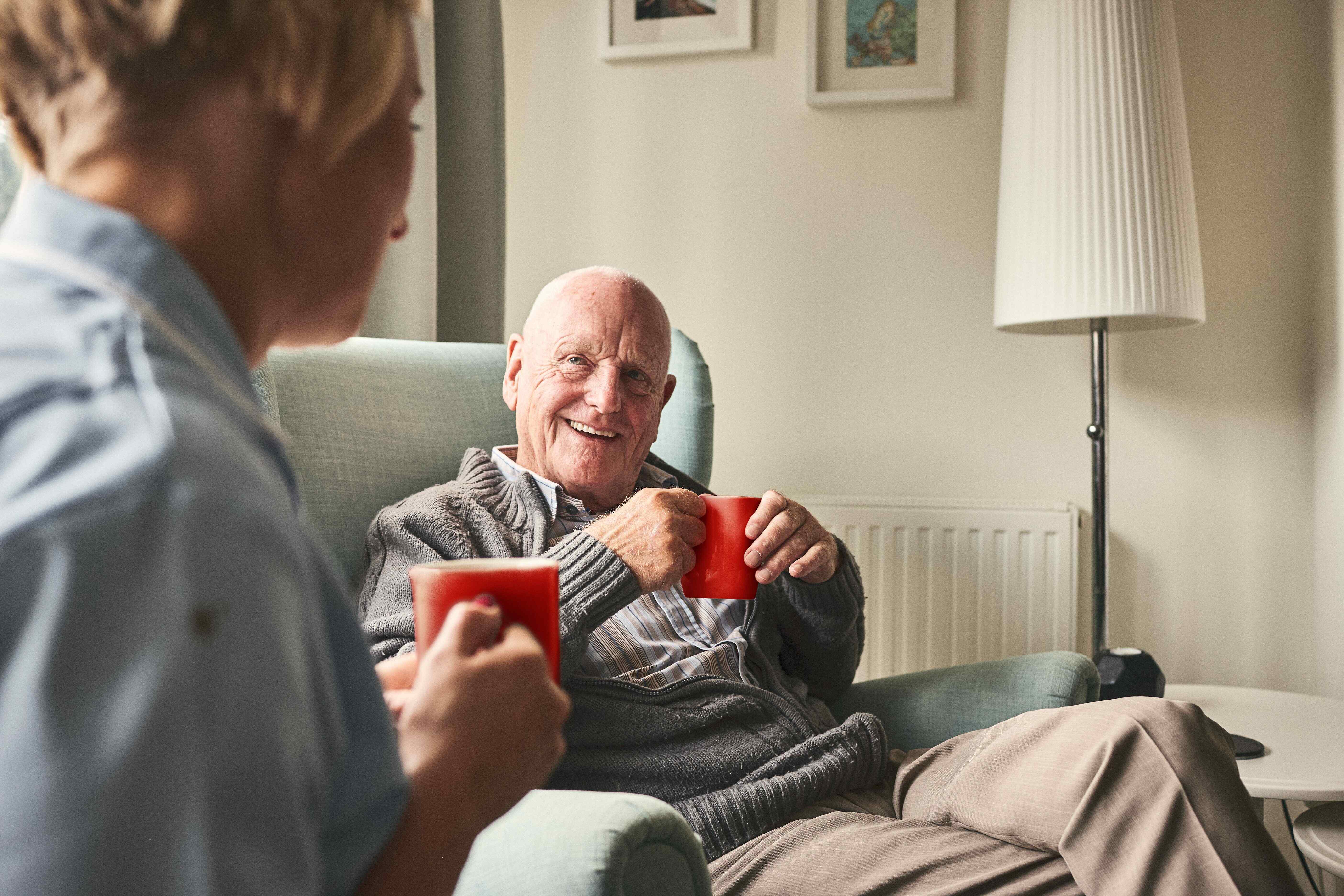 Resident of a care home chatting with nurse whilst drinking nescafe instant coffee