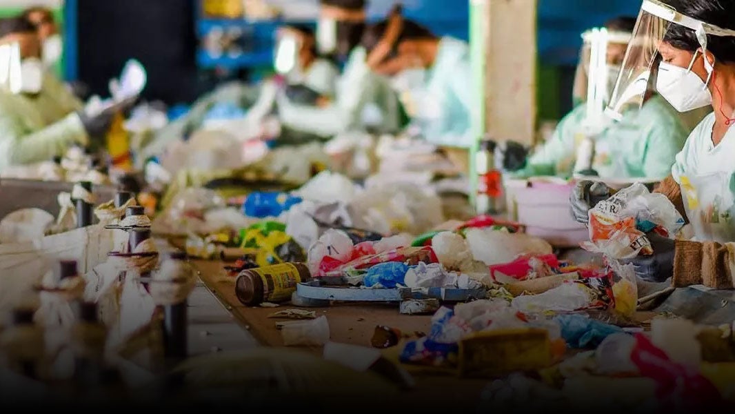 people sorting through trash for recycling