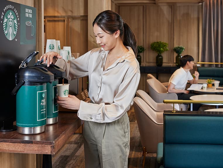 Woman dispensing coffee into a cup