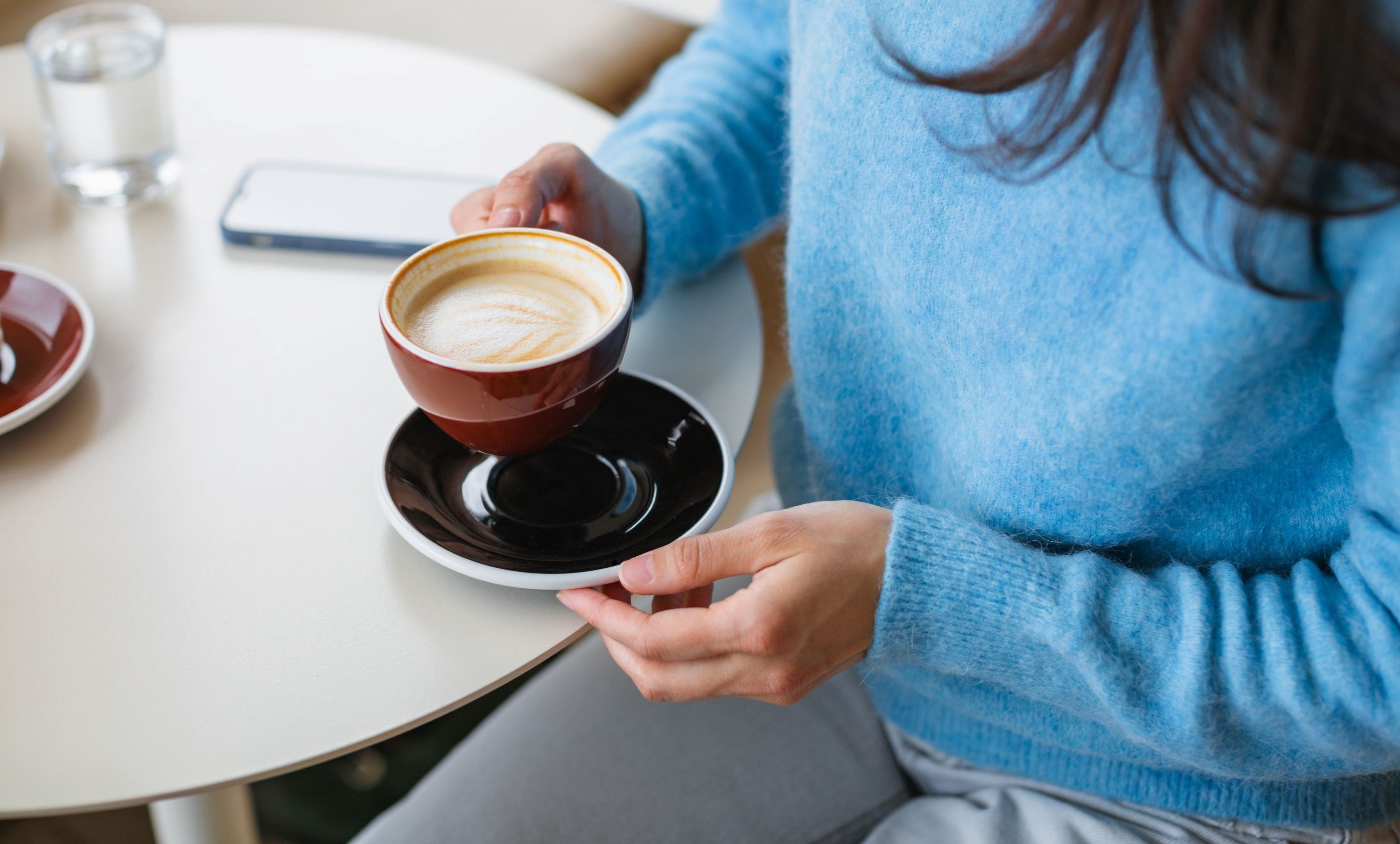 woman holding a flat white