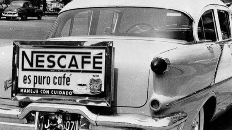 A car from the 1950s with an old Nescafé advert on its bumper