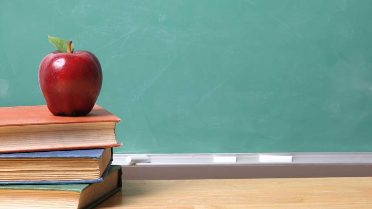 a stack of books with an apple on top
