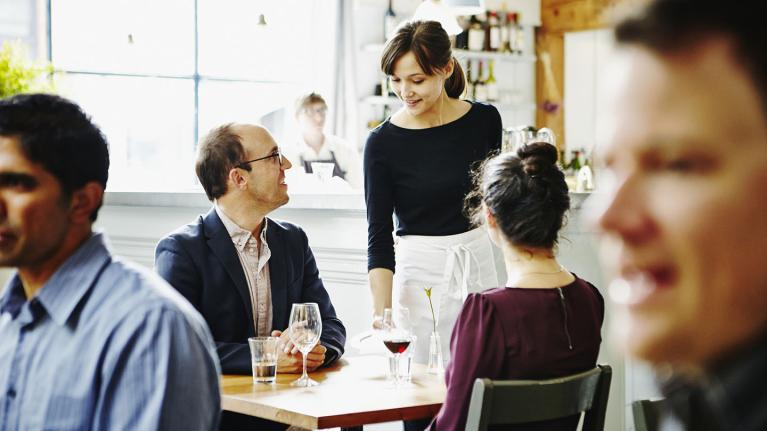 A waiter talking to two customers