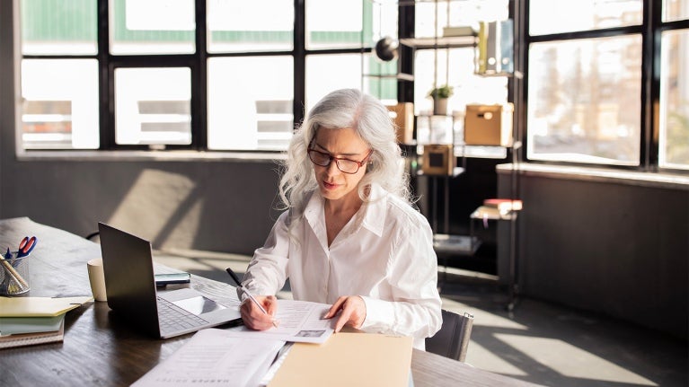manager signing papers at desk 