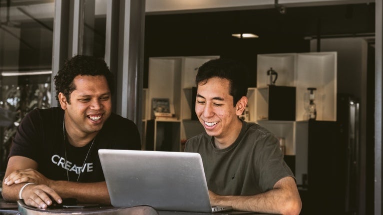 two colleagues looking at a laptop