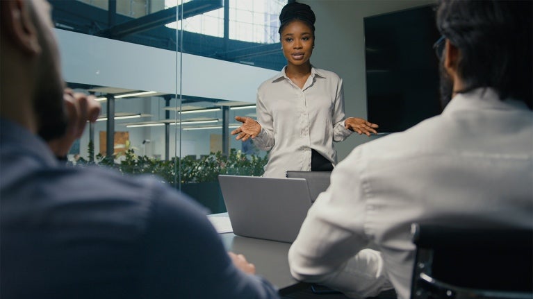 manager standing up and coaching employees