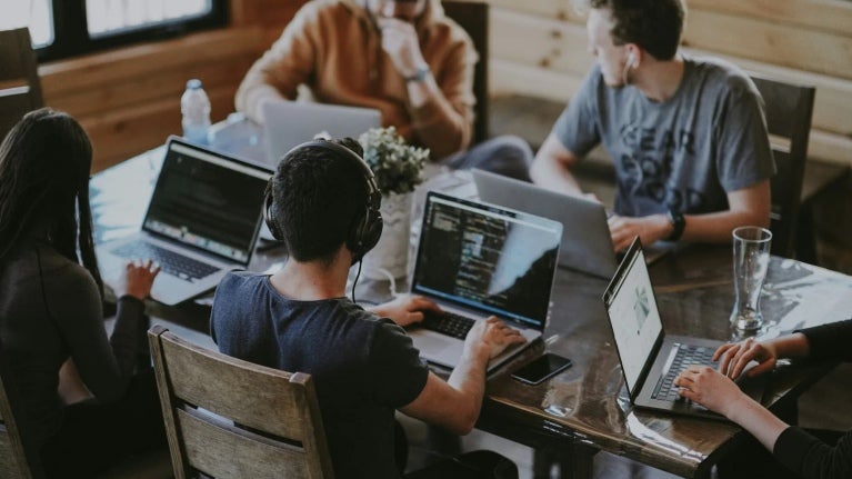 people working on laptops within coworking space