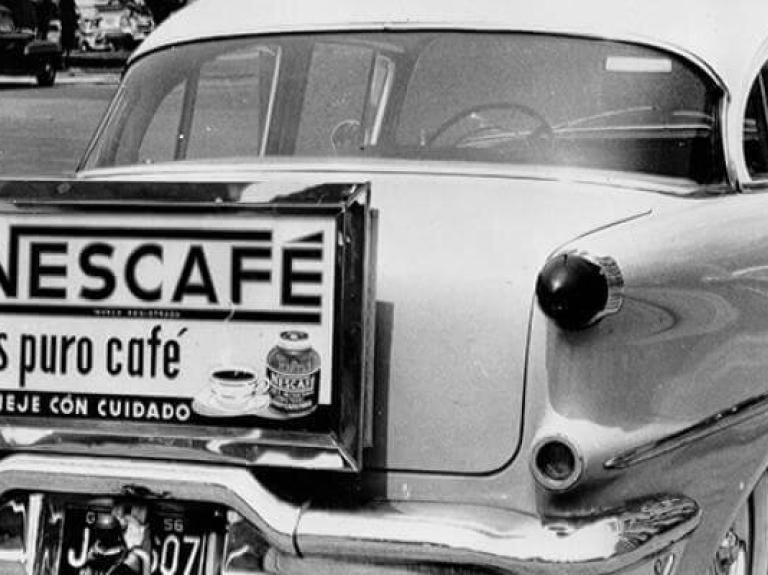 A car from the 1950s with an old Nescafé advert on its bumper