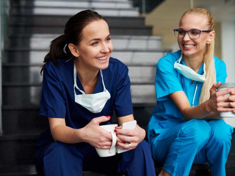 nurses drinking coffee on stairs