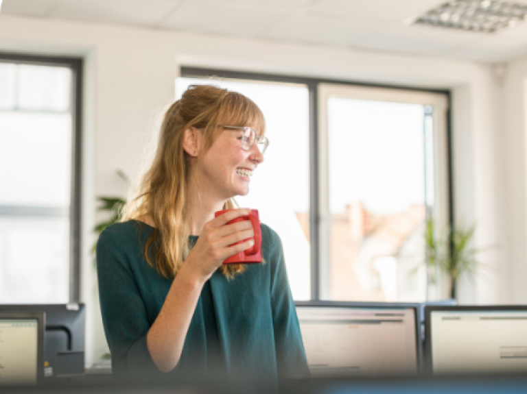 woman drinking NESCAFE in her office