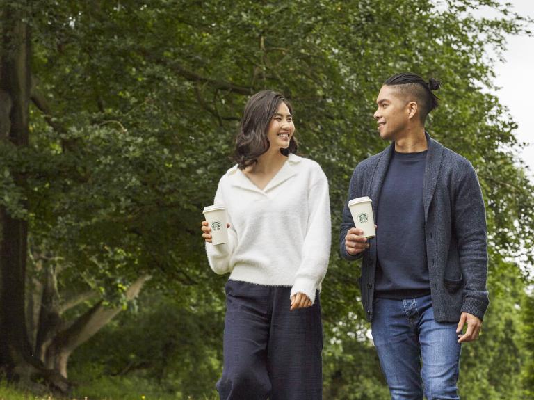 two people walking with a starbucks drink