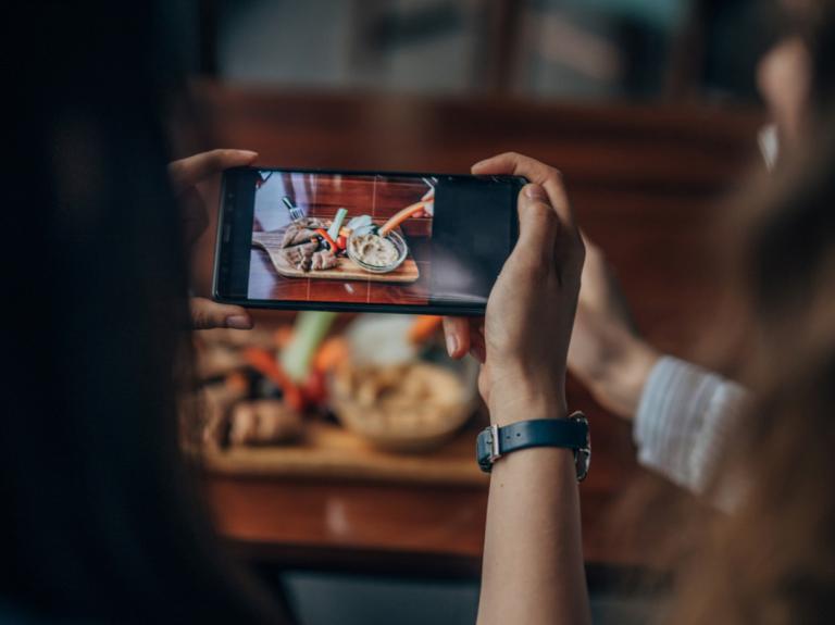 A person taking a picture of food