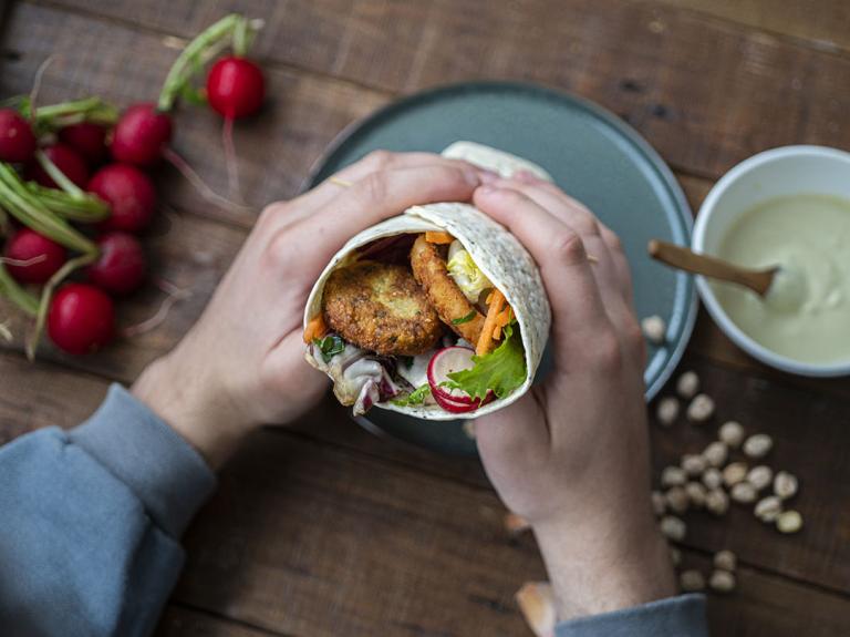 Person holding a vegan wrap