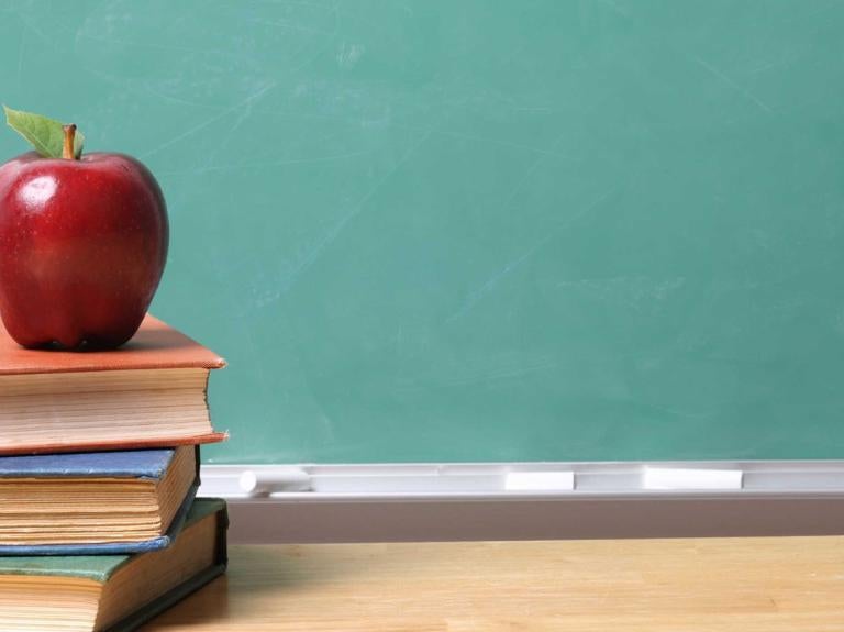 a stack of books with an apple on top