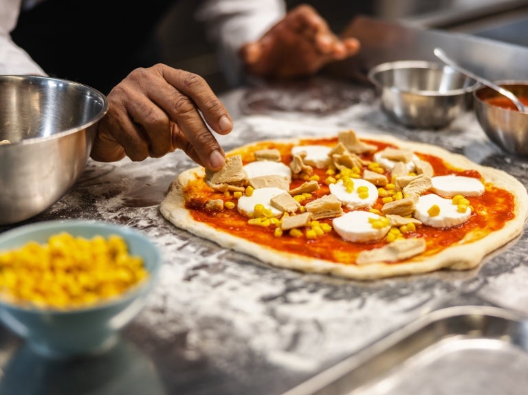 chef making pizza using garden gourmet fillet pieces