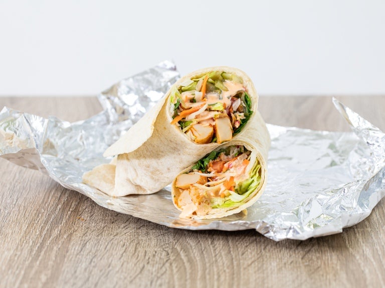 bang bang veggie wrap placed on foil on a table