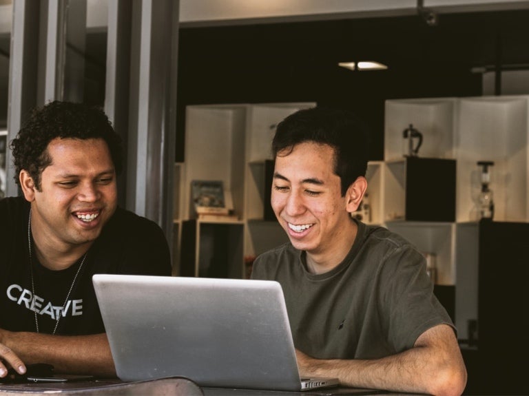 two colleagues looking at a laptop