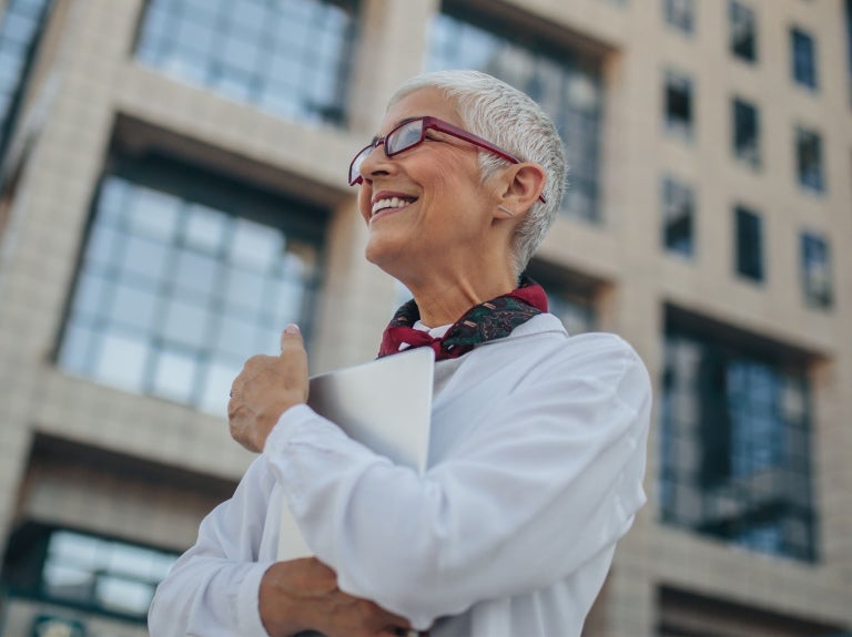 woman smiling outside an office building