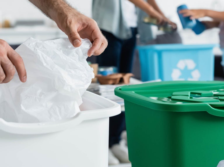 people sorting waste into different recycling bins, promoting environmental sustainability