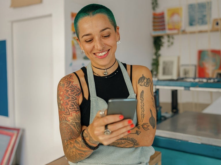 artist in her studio checking phone