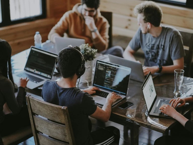 people working on laptops within coworking space