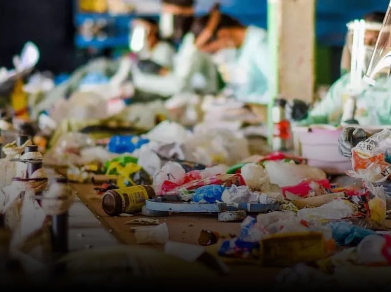 people sorting through trash for recycling